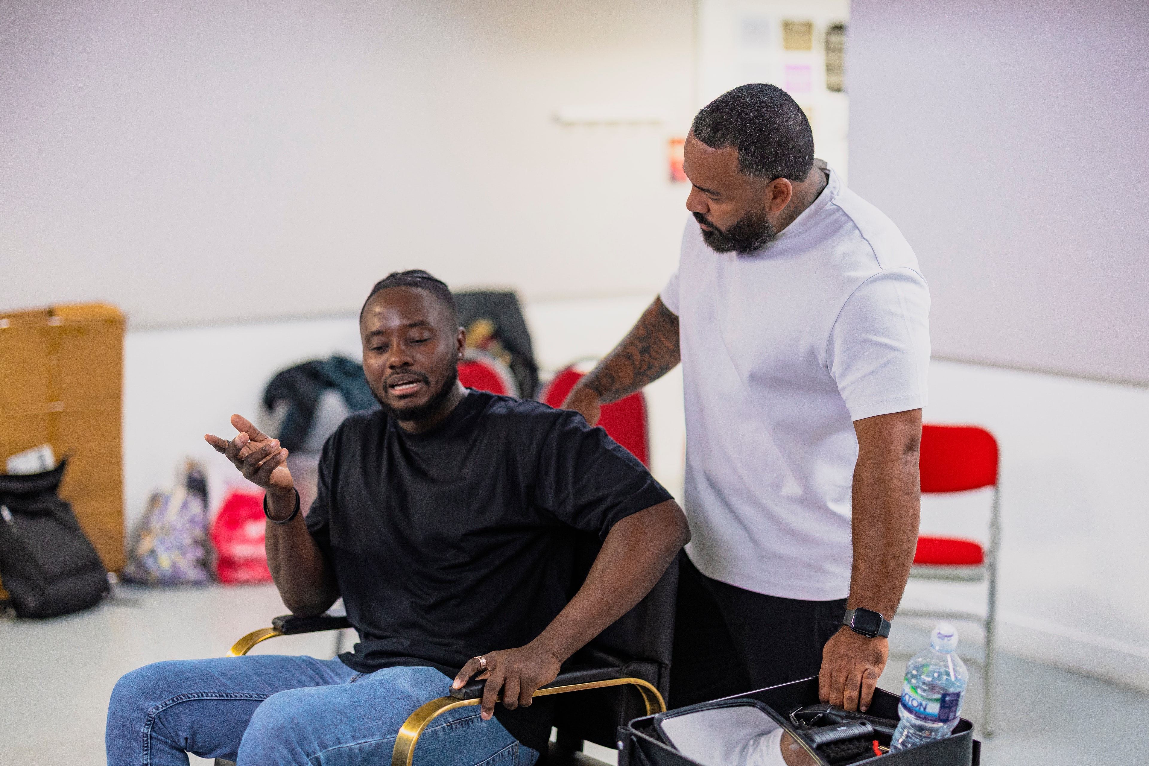 Director guiding a cast member through a scene in the barbershop chair