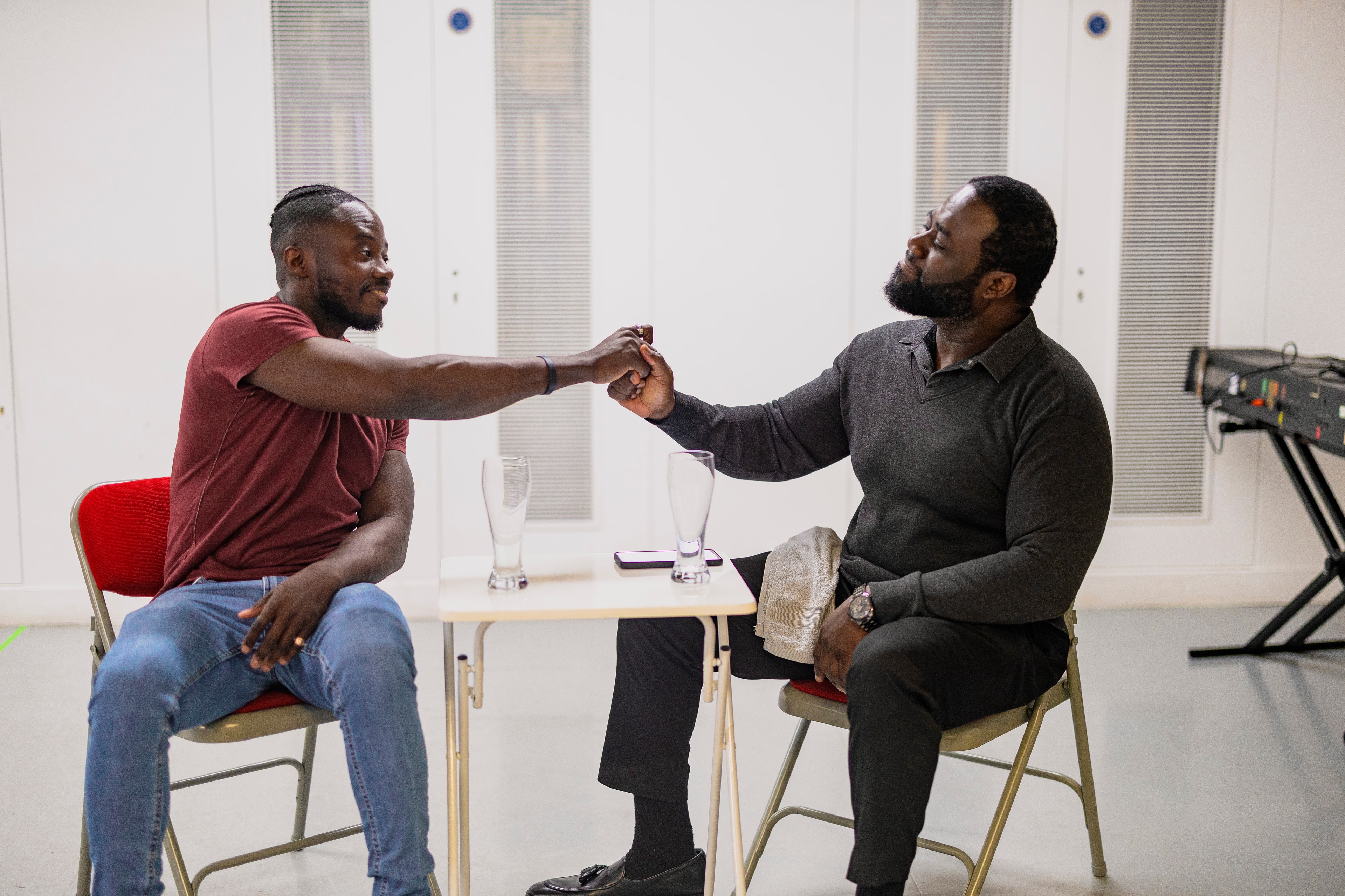 Two cast members in conversation during rehearsal